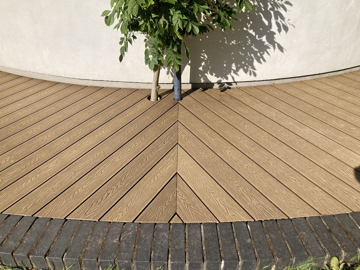 Composite boards meeting in a herringbone point around a tree