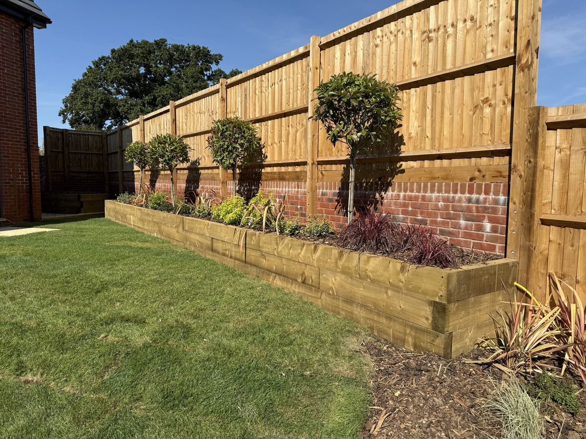 New closeboard fence above a sleeper raised bed