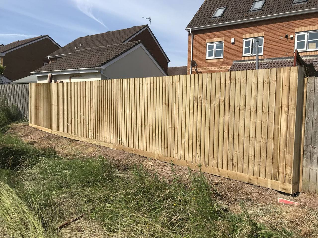 Long new featheredge fence run along a garden boundary