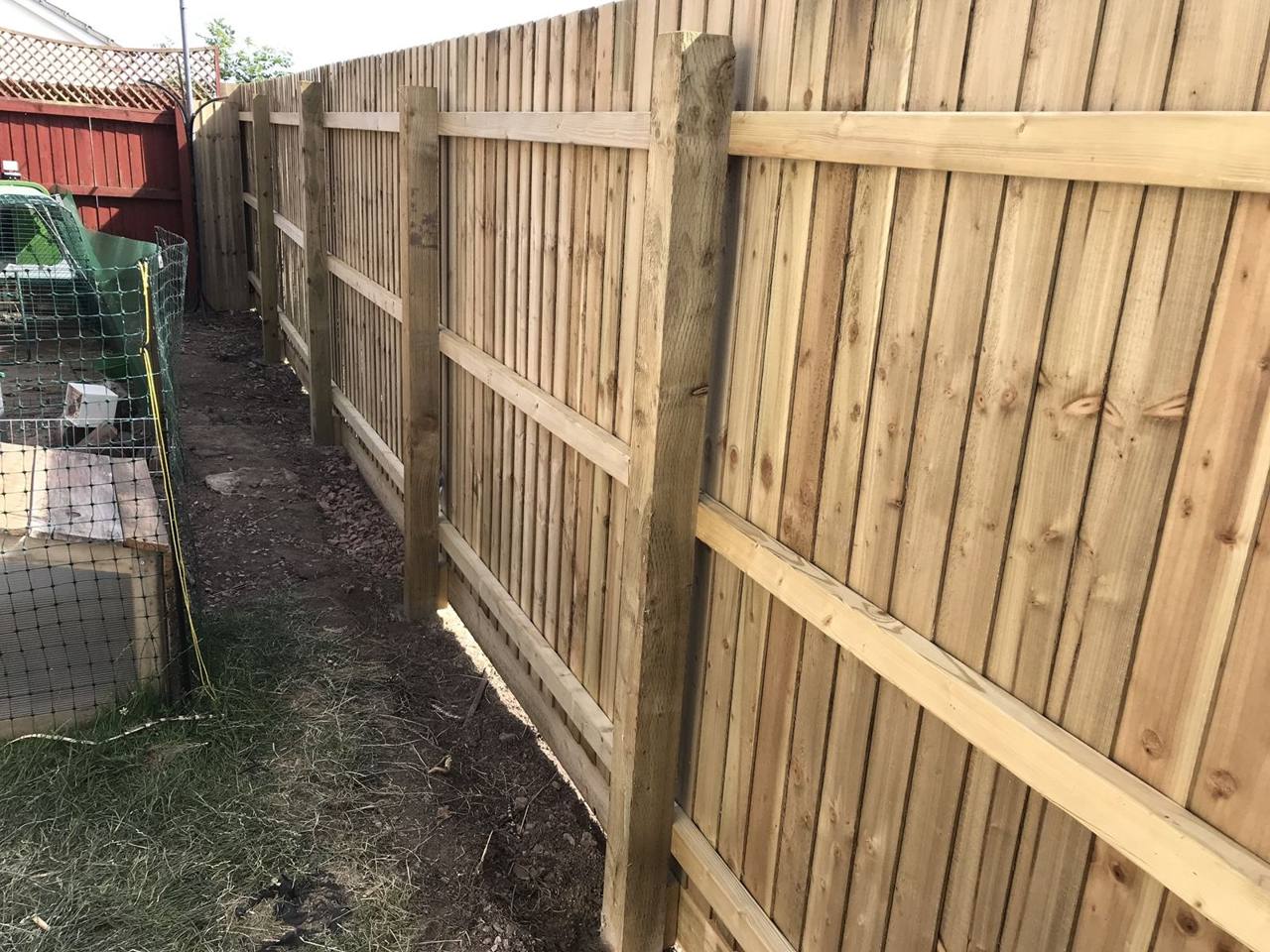 Rail side of a featheredge fence showing posts, rails and gravel boards